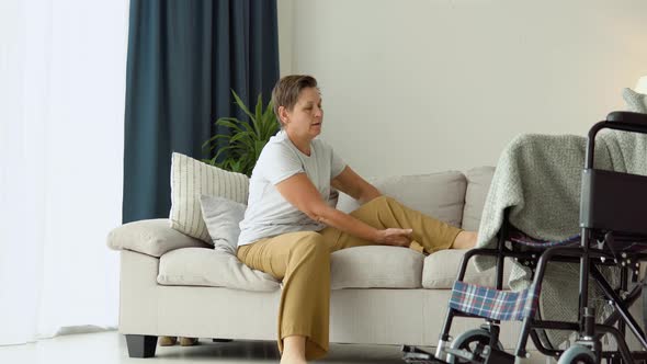 Senior Woman Wants Having Difficulty Getting Into a Wheelchair From Sofa alt