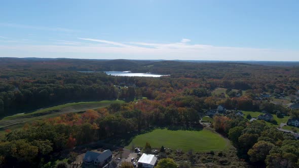 Water reflection and autumn color forest near town of Haverhill, aerial descend shot alt