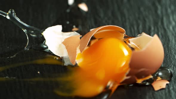 Super Slow Motion Shot of Falling and Breaking Whole Egg on Black Table at 1000 Fps. alt