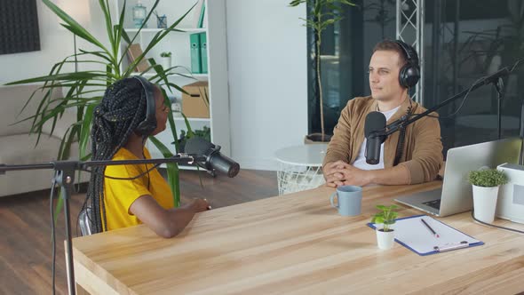 Female Host Talking to a Guest Friend on a Podcast Radio Station in the Studio alt