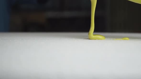 Beautiful slider shot of epoxy resin for surfboard glassing process. Smoothly pouring yellow paint o alt