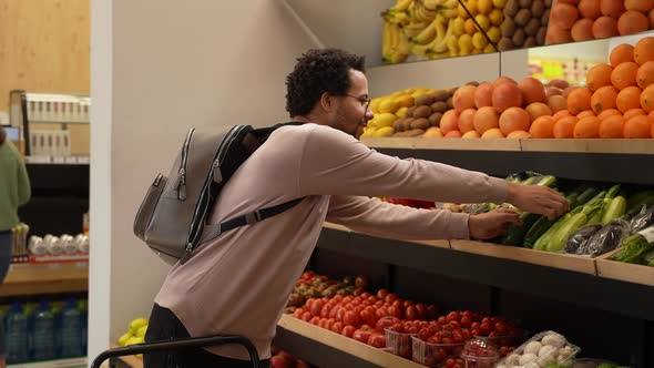 Male Buyer Choosing Vegetables in Grocery Store alt