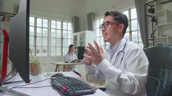 Asian Male Doctor Communicates With Patient By Video Link, Doctor Consults Patient alt