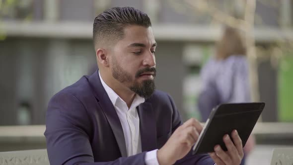 Serious Handsome Businessman Using Tablet Pc Outdoor alt