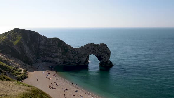 People relaxing at Durdle Door beach in Jurassic Coast near Lulworth in Dorset, England. Aerial risi alt