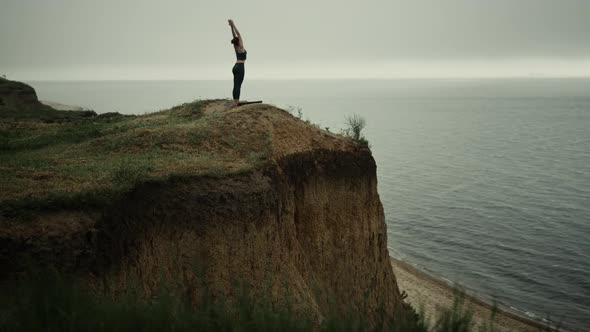 Athletic Woman Stand Straightening Up Beach Hill Stretch Hands to Gray Sky alt