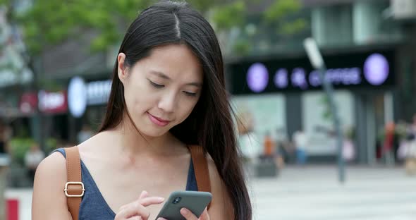 Woman use of mobile phone in city alt