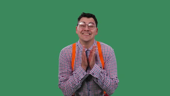 The Man Looks Straight Ahead and Claps His Hands with a Happy Smile on His Face alt