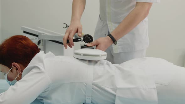 the Doctor Performs a Shock Wave Therapy Procedure to Treat the Patient's Back alt