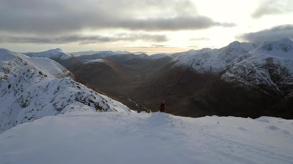 Mountaineer on the Summit of a Snowy Mountain alt