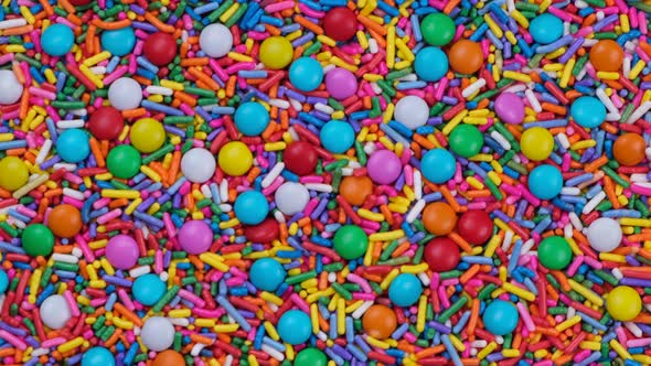 Rotating Background of Multicolored Sprinkles for Sweets and Multicolored Dragees or Sweets