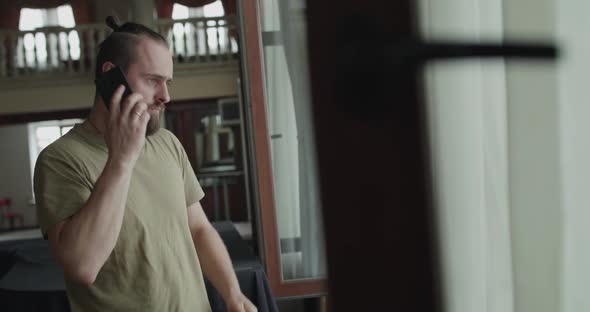 The Man Receives the Call and Has a Pleasant Conversation on a Mobile Phone alt