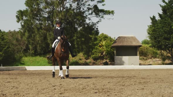Caucasian woman riding her dressage horse alt