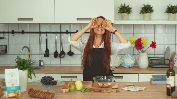 Playful Caucasian Girl Having Fun at Cozy Kitchen. Funny Red Head Girl. alt