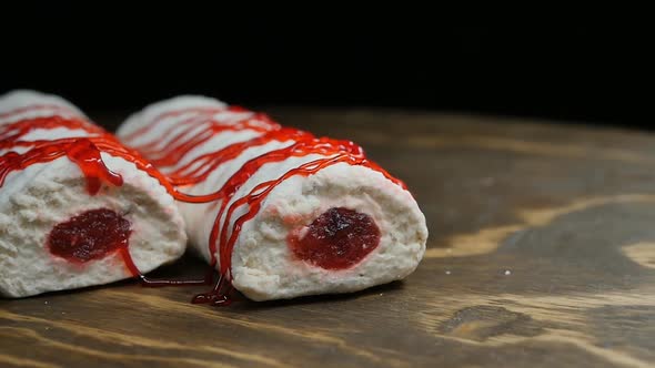 White Marshmallow Sprinkled with Red Syrup Two Sticks on a Wooden Background