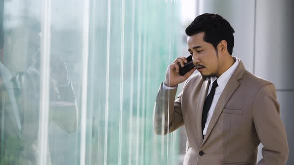 young stressed business man talking with mobile phone in office