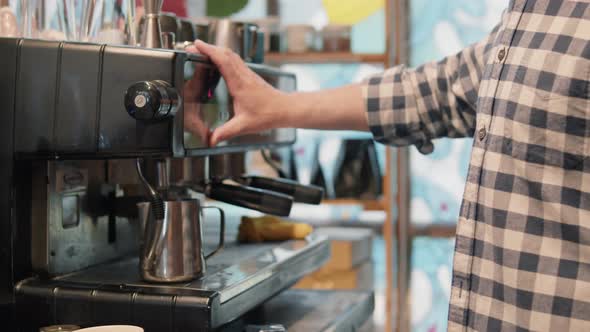 Male barista makes coffee with coffee machine