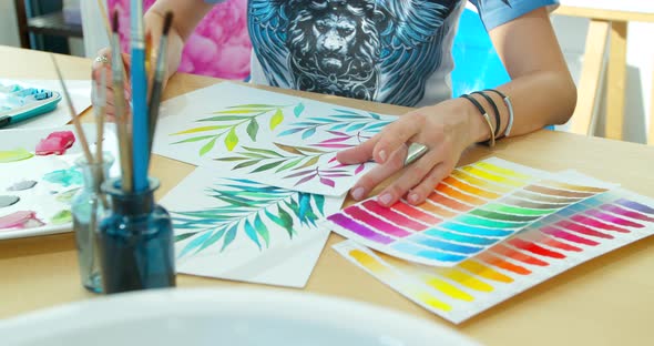 The Artist Paints Flowers, Watercolor Drawing. Hand Drawing with a Brush, Female Hand with a Brush alt