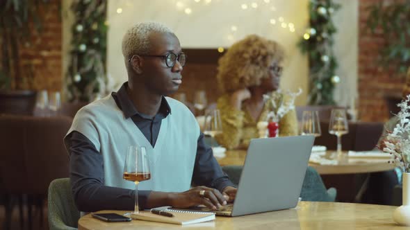 African American Man Working on Laptop in Cafe alt