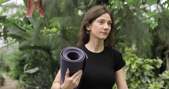 Portrait of Pretty Brunette Woman Caming to the Beautiful Botanical Garden for Doing Yoga Exercises