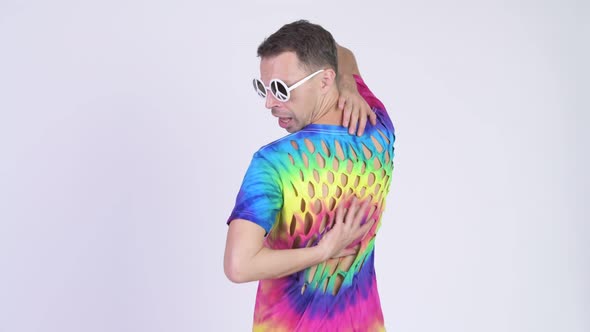 Rear View of Hippie Man Wearing Sunglasses with Peace Sign and Looking Back alt