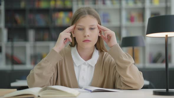 School Girl Having Headache Massaging Head in Class