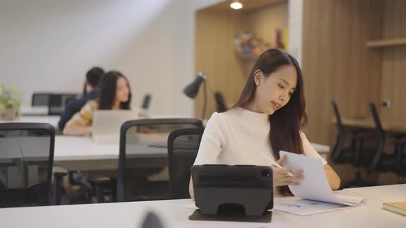 Asian woman working in the office coworking space.