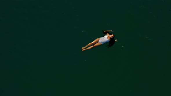 Aerial Shot of a Young Woman Enjoying a Swim Lying in the Water