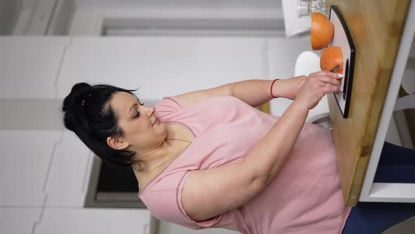 Attractive Overweight Woman Preparing Healthy Meal Cutting Grapefruit Closeup alt