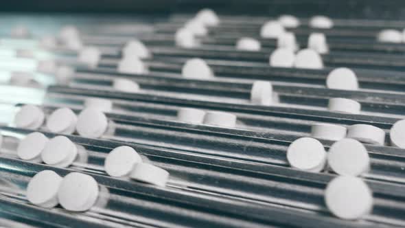 Tablets in the Creases of a Moving Metal Conveyor alt