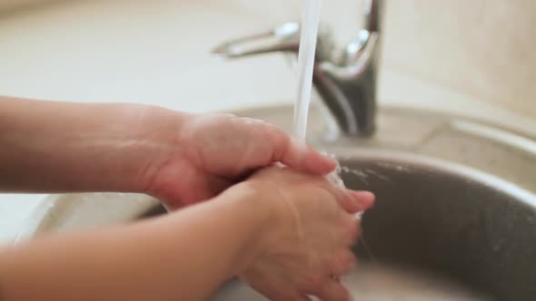Washing and Rinsing Female Hands in Kitchen Sink Close Up