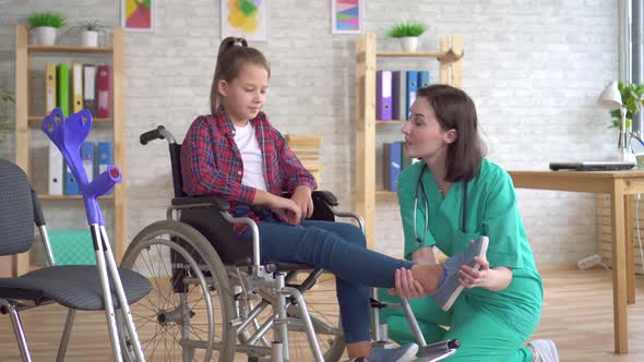 Teenage Girl After an Injury in a Wheelchair at the Reception of a Doctor alt