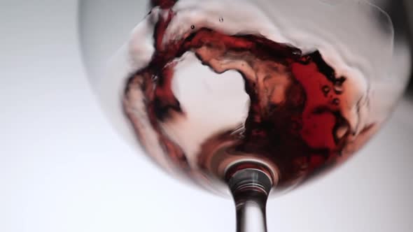 Red Wine Being Poured Into a Wine Glass a White Background alt