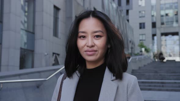 Portrait of a Young Adult Asian Woman Smiling Outdoors alt