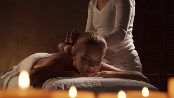 Young, healthy and beautiful woman gets massage therapy in the spa salon. alt