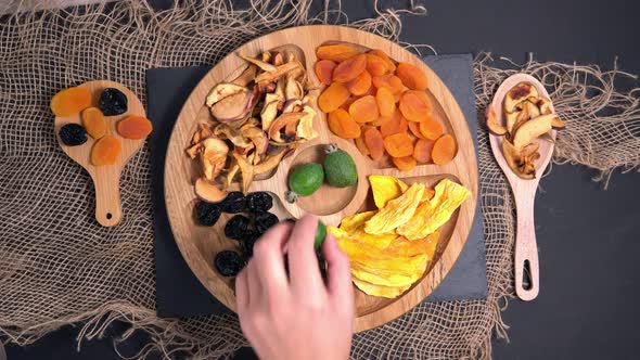 Dried Fruit Top View in a Wooden Plate. Mango, Apples, Prunes, Dried Apricots Feijoa. Healthy Snacks alt