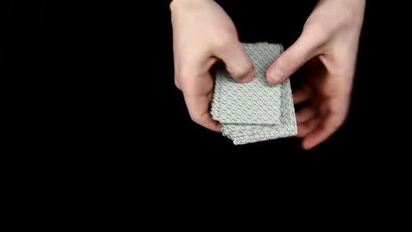 Playing Cards Being Spread, Like Fan, on a Black Surface By Magician alt