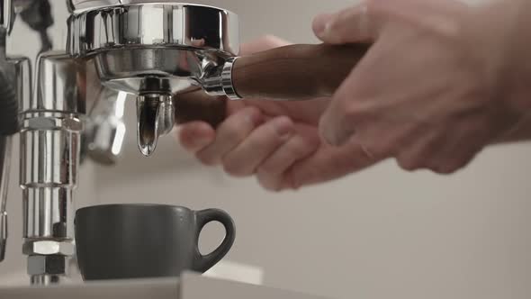 Slow Motion Espresso Pour From Single Spout Portafilter Into Black Cup