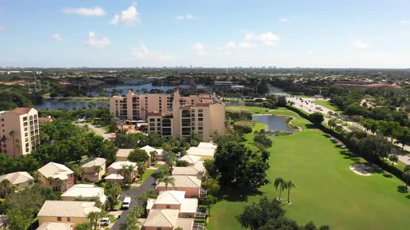 Aerial view of a neighborhood and condominiums along a golf course alt