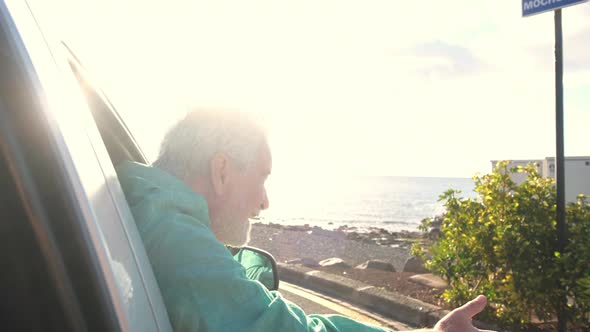 close up of one mature man outside of the window's car looking and enjoying the outdoors alt