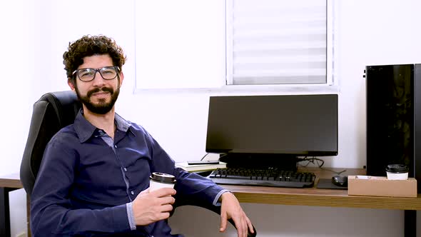 Handsome business latin man smiling to the camera and toasting. Steady capture. Home office break su alt