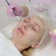 A Young Woman Gets A Procedure From A Beautician.Cosmetologist Making Cosmetic Facial White Mask  - VideoHive Item for Sale