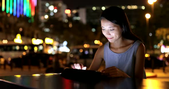 Asian Woman use of tablet computer at night 