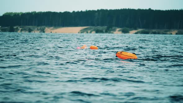 Two Open Water Swimmers Swimming with a Floating Bags in a River alt