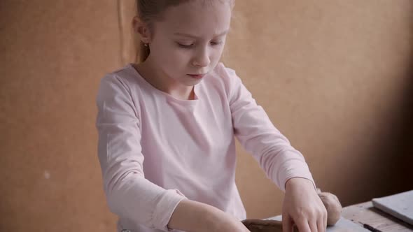 Little Girl Working with Clay in Pottery Workshop Studio
