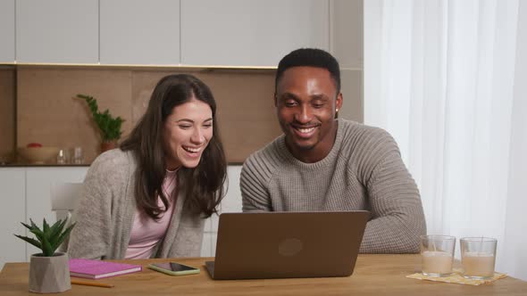 A Couple Having an Online Conference Video Call with Their Friends at Their Apartment Kitchen alt