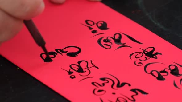 Vietnamese scholar writing calligraphy on the red envelope, ang pao in the lunar new year