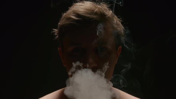 Smoker exhales out a smoke