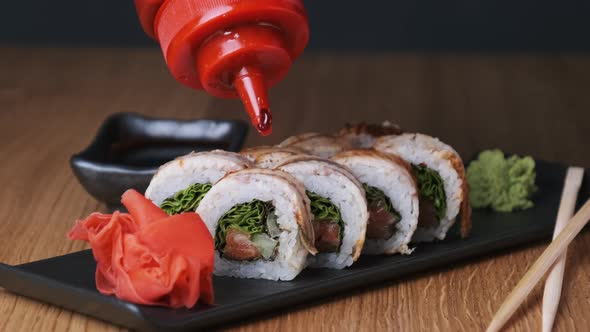 Appetizing Sushi is Poured with Sweet Sauce on a Wooden Table in Restaurant alt