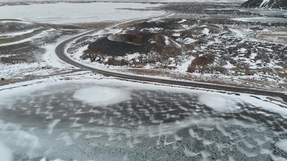 Aerial View of Frozen Lake, Road and Volcanic Crater in Highlands of Iceland. alt